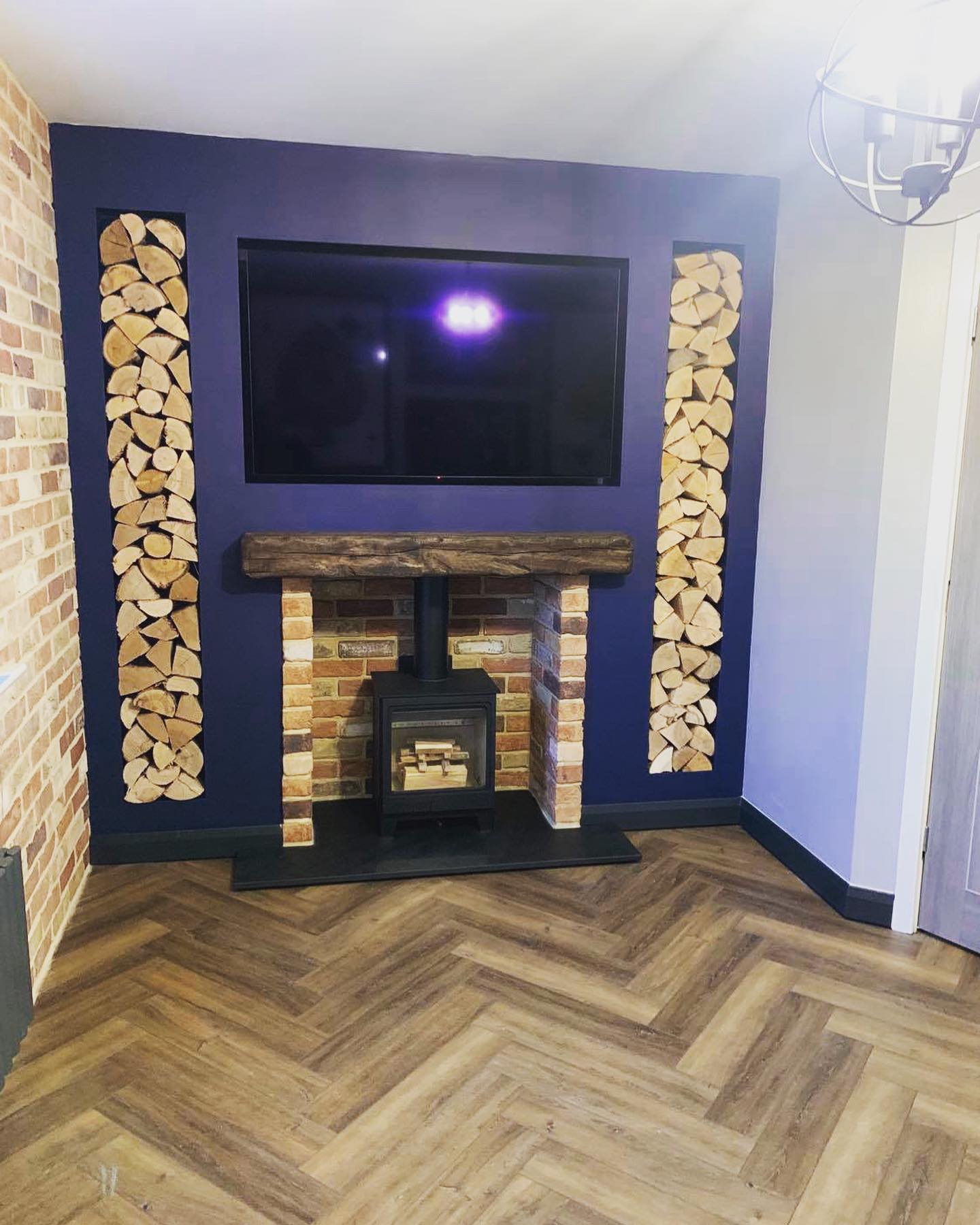 First-Floor Stove Media Wall with Built-In Log Storage