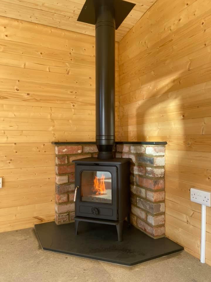 Summerhouse Stove Installation with Reclaimed Brick Heat Shield